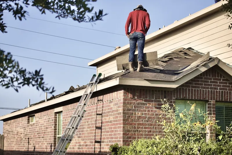 Professional roofer working on a residential roof in Powers Corner